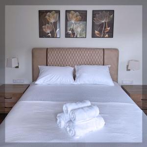 a bedroom with a bed with towels on it at Favelas Luxury Apartments in Kavála