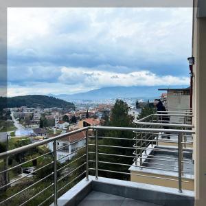 a person standing on a balcony looking at a city at Favelas Luxury Apartments in Kavála