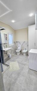 baño con 2 aseos y lavamanos en koman_lakeview_apartments, en Shkodër