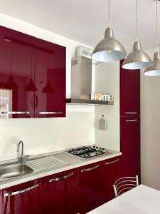una cocina con armarios rojos y fregadero en Il Piccolo Borgo, en Valdobbiadene