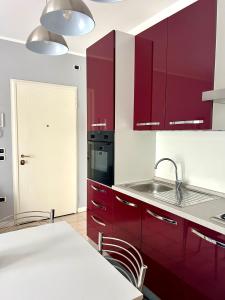 una cocina con armarios rojos y fregadero en Il Piccolo Borgo en Valdobbiadene