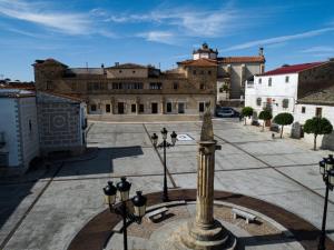 a building with a statue in the middle of a courtyard at El Reloj De La Villa in Valdefuentes