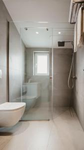 a bathroom with a glass shower and a toilet at BAZ'HUR Boutique Hotel in Kukës