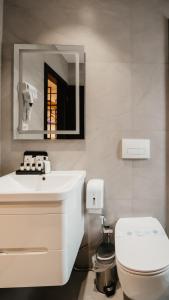 a bathroom with a white sink and a toilet at BAZ'HUR Boutique Hotel in Kukës