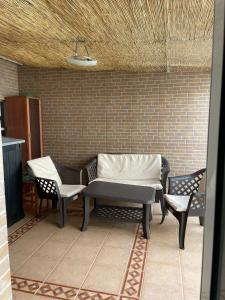 patio z 2 krzesłami, ławką i ścianą w obiekcie APARTAMENTO CERCANO AL CENTRO w Walencji