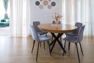 a dining room table with blue chairs and a vase of flowers at שלווה בגלבוע in Gid‘ona