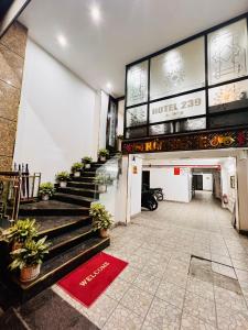 um lobby de um hotel com escadas e vasos de plantas em Khách Sạn 239 em Hanói