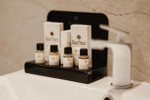 a shelf with five bottles of hair products on it at BAZ'HUR Boutique Hotel in Kukës