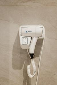 a white phone with a cord plugged into it at BAZ'HUR Boutique Hotel in Kukës