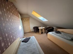 a room with two beds and a table with chairs at Žilina in Marijampolė