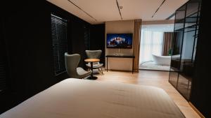 a bedroom with a bed and a bathroom with a tub at BAZ'HUR Boutique Hotel in Kukës