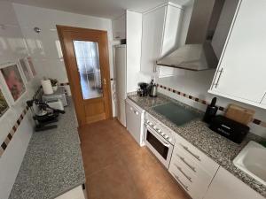 uma cozinha com armários brancos e uma bancada em MARGO EL EDEN Residencial em Gandia