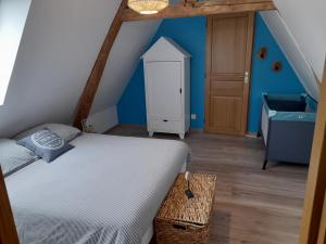 1 dormitorio con cama y pared azul en Gîte de la giroterie, maison à la campagne au calme, vue sur la vallée, 