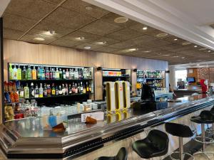 a bar with a counter withools and bottles of alcohol at Hotel Astoria Park in Lloret de Mar