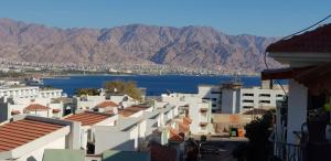 a view of a city with mountains and a body of water at Amdar Village Cottage עם ממ"ד in Eilat