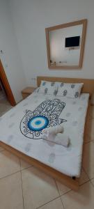 a bed with a picture of a woman on it at Amdar Village Cottage עם ממ"ד in Eilat