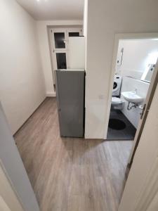 a bathroom with a refrigerator in the middle of a room at Modern Apartment Hagen - Dortmund in Hagen