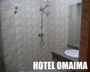 y baño con ducha, aseo y lavamanos. en Hotel OMAIMA, en Laayoune