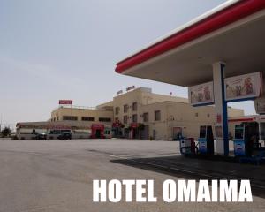 um sinal de hotel omma em frente a um posto de gasolina em Hotel OMAIMA em El Aiune