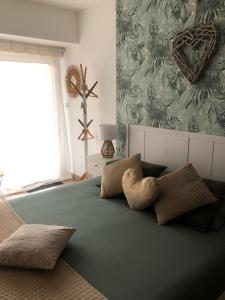 una camera da letto con un grande letto verde con cuscini di La Carola a Bordeaux-Saint-Clair