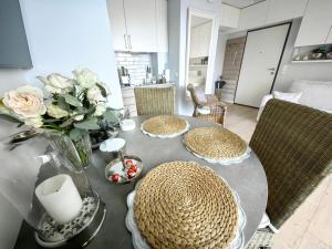 una mesa de comedor con sillas y un jarrón de flores en Edel Exclusive Apartments Horyzont 414 Especially for You en Międzyzdroje