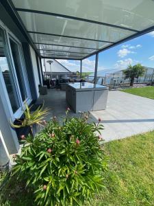 un porche cubierto con una mesa y una planta en La Villa Kat'Etoiles, 