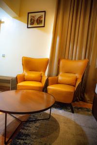 two orange chairs and a table in a room at Box Residence Hotel in Lagos