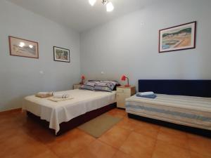 a bedroom with two beds in a room at Guest House Dobriša in Vinišće