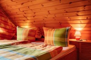 a bed in a room with a wooden ceiling at Blockhaus 2 in Steina