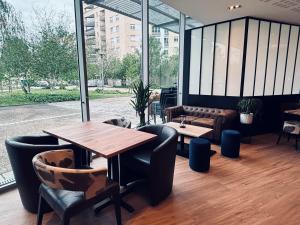 a restaurant with a table and chairs and a couch at ibis Lyon Caluire Cité Internationale in Caluire-et-Cuire