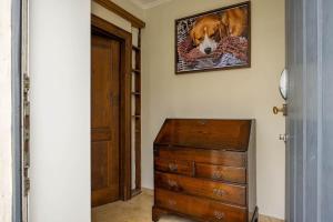 a room with a dresser and a picture of a dog at Maison Gaston in Bruges
