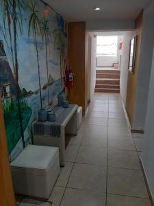 un pasillo con dos bancos y una pintura en la pared en Hotel Gran Córdoba en La Falda