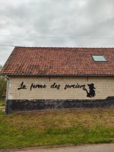 een schilderij van een hond aan de zijkant van een gebouw bij La ferme des sorciers in Agnez-lès-Duisans