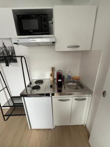 a small kitchen with a stove and a microwave at Esprit ANGLETERRE in Mulhouse