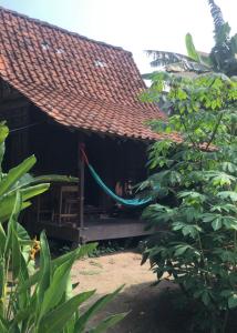 a person sitting on the porch of a house at Omah Guyub 2 in Jarakan