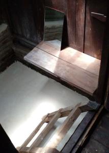 a mirror sitting on top of a wooden floor at Omah Guyub 2 in Jarakan