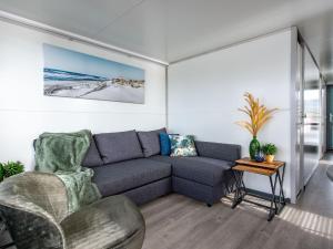 a living room with a couch and a table at Waterlodge Blue Lagoon on a jetty for 4 people in Kamperland