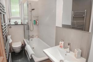 La salle de bains est pourvue d'un lavabo, d'une baignoire et de toilettes. dans l'établissement Chic & bright flat near Holyrood Park, à Édimbourg