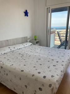 a bedroom with a bed with a view of the ocean at Beach Apartment in Vilanova i la Geltrú