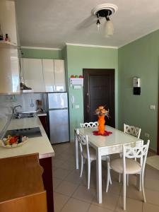 a kitchen with a table with a vase on it at Roy Apartments in Durrës +5 photos