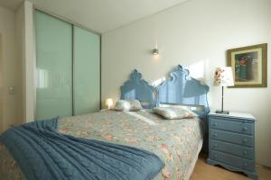 um quarto com uma cama azul e uma cómoda em Host In Olivença em Vila Nova de Famalicão
