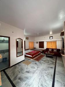 Laxmanji villas في مونت ابو: غرفة معيشة كبيرة مع سرير ومرآة