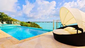 un resort con piscina e chaise longue di Alta Bella Villa and Spa a Providenciales