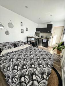 ラ・ロシェルにあるJoli appartement avec parkingのリビングルーム(ベッド1台付)、キッチンが備わります。