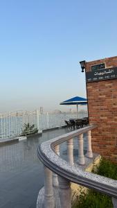 un patio con tavoli e ombrellone su un edificio di منتجع درة الشرق للعائلات a Dammam