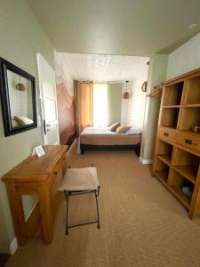 een kamer met een slaapkamer met een bed en een bureau bij Les Cottages d'Orient Premium in Mesnil-Saint-Père