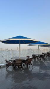uma mesa e cadeiras debaixo de um guarda-sol num telhado em منتجع درة الشرق للعائلات em Dammam