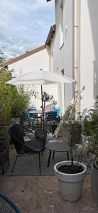 a patio with a table and chairs and an umbrella at Chez ROSE in Bruyères