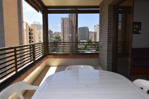 a white table and chairs on a balcony with a view at CASTELMAR 2 DORMITORIOS - Fincas Arena in Benidorm +10 photos