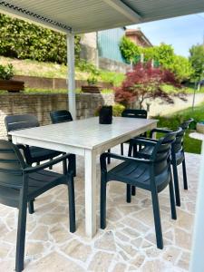 een witte tafel en stoelen op een patio bij Il Piccolo Borgo in Valdobbiadene